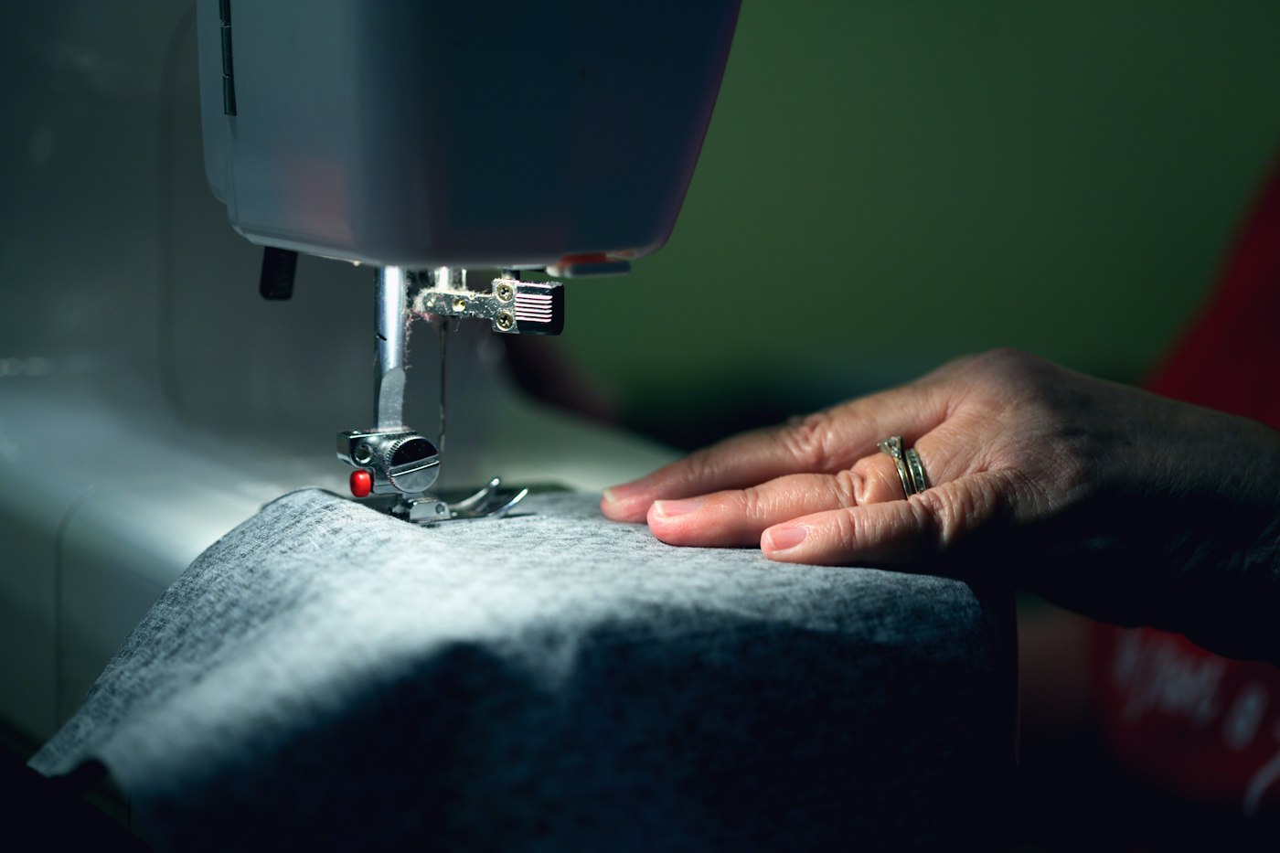 A tailor's hands guiding fabric through a sewing machine — D&S Clothing Alteration & Dry Cleaning, Birmingham